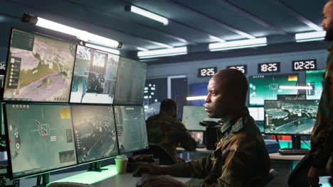 Military-officers-looking-at-tracking-equipment-screens-to-gain-intel