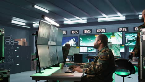 Intelligence-corps-agent-checking-screens,-discussing-with-colleague