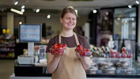 Porträt-Einer-Glücklichen-Supermarktangestellten,-Die-Zwei-Kisten-Mit-Roten-Erdbeeren-In-Den-Händen-Hält