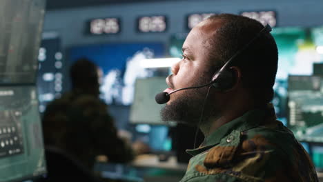 Military-dispatcher-managing-communications-networks,-looking-at-screens