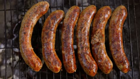 Delicious-juicy-sausages,-cooked-on-the-grill-with-a-fire.