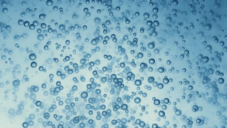 Many-water-bubbles-in-blue-water-close-up,-abstract-water-wave-with-bubbles-in-slow-motion.