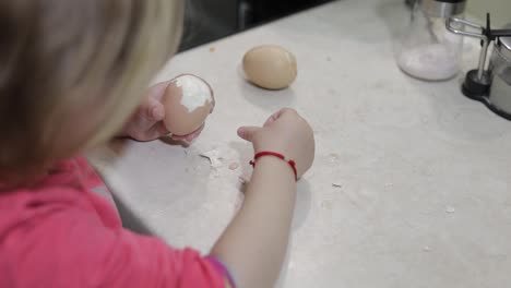 Closeup-of-a-little-girl-cleans-the-shell-with-a-boiled-chicken-egg