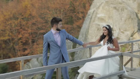 Groom-with-bride-on-a-bringe-near-mountain-hills-in-the-forest.-Wedding-couple