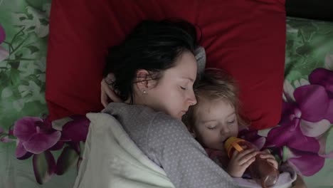 Sleepy-young-woman-with-her-baby-does-not-want-to-wake-up-in-the-morning