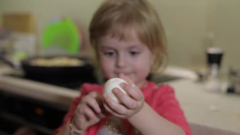 Closeup-of-a-little-girl-cleans-the-shell-with-a-boiled-chicken-egg