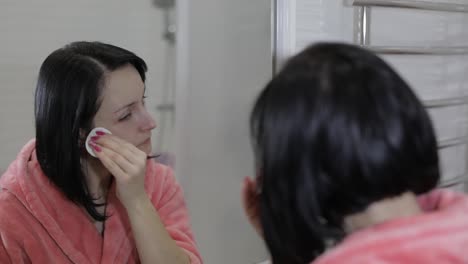 Beautiful-brunette-woman-using-cotton-pads.-Woman-removing-makeup