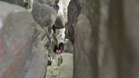 Groom-with-bride-standing-in-cave-of-mountain-hills.-Wedding-couple-in-love