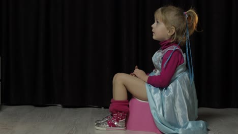 Little-girl-sitting-on-the-potty-and-watching-TV