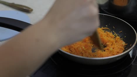 Chopped-carrots-fried-in-vegetable-oil-in-the-pan.-Close-up