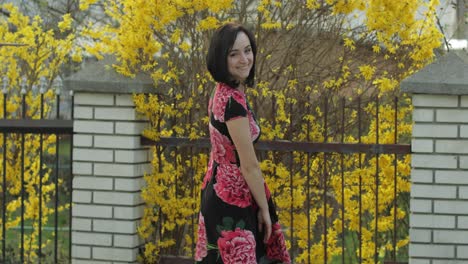 Attractive-young-woman-in-a-dress-with-flowers-dancing.-Cute-girl