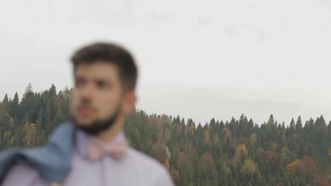 Young-man-on-the-hill-of-a-mountain-with-jacket.-Businessman.-Bridegroom.-Groom