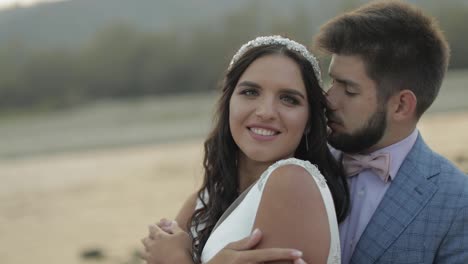 Wedding-couple-standing-near-mountain-river.-Groom-and-bride-in-love