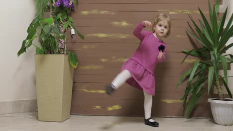 Little-child-dance-near-flowerpots-and-wooden-fence.-Feel-happy,-smiling