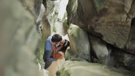 Groom-with-bride-standing-in-cave-of-mountain-hills.-Wedding-couple-in-love