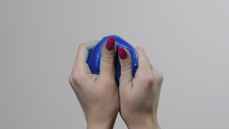 Woman-hands-playing-with-oddly-satisfying-blue-slime-gooey-substance.-Antistress