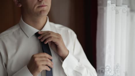 Handsome-groom-fixes-his-tie.-Wedding-morning.-Businessman.-Slow-motion