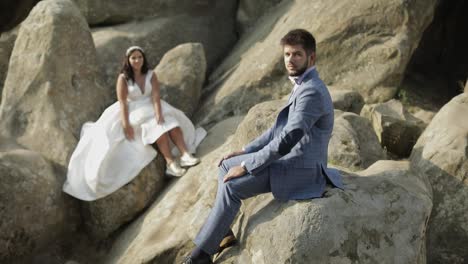 Groom-with-bride-sit-on-a-slope-of-the-mountain.-Wedding-couple.-Happy