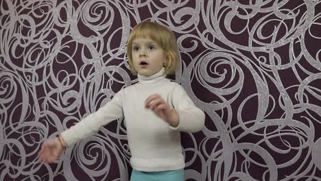 Little-happy-child-dancing-on-sofa-and-listening-music-at-home.-Slow-motion