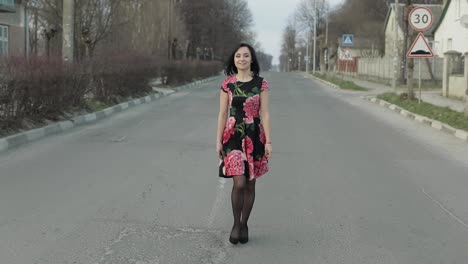 Una-Joven-Atractiva-Con-Un-Vestido-Con-Flores-Caminando-Por-La-Carretera.