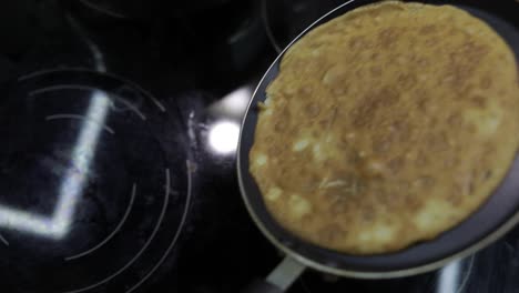 The-process-of-cooking-homemade-pancakes.-Woman-puts-pancake-from-pan-to-plate