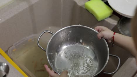 Child-washing-dishes-in-the-kitchen.-Close-up-of-girls-hands