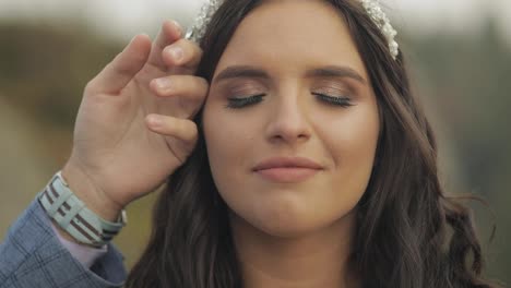 The-face-of-the-beautiful-bride.-The-grooms-hand-gently-caresses-her-cheek