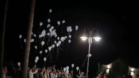 Blinking-helium-balloons-flying-at-night-sky.-Balloons-in-wedding-party