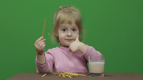 The-child-eats-cookies.-A-little-girl-is-eating-cookies-sitting-on-the-table.