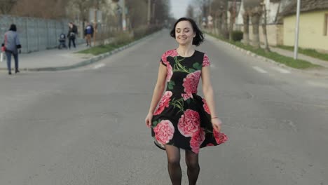 Una-Joven-Atractiva-Con-Un-Vestido-Con-Flores-Caminando-Por-La-Carretera.