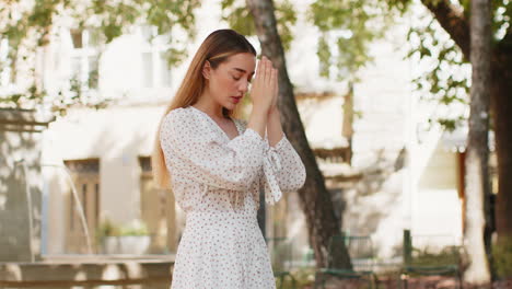 Mujer-Joven-Caucásica-Rezando-Con-Los-Ojos-Cerrados-A-Dios-Pidiendo-Bendición-Ayuda-Perdón-Al-Aire-Libre