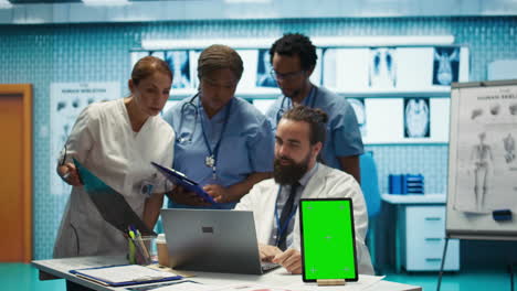 Grupo-De-Médicos-Consultando-Registros-Hospitalarios-Junto-A-Una-Pantalla-De-Clave-Cromática