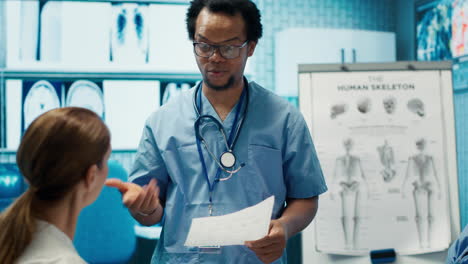 Fachassistent-Bespricht-Krankenhausunterlagen-Mit-Spezialistenteam-In-Einer-Besprechung