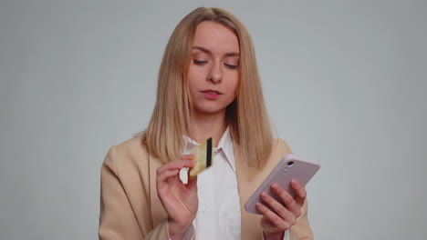 Woman-using-credit-bank-card-and-smartphone-while-transferring-money-purchases-online-shopping