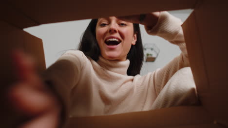 Happy-young-woman-shopper-unpacking-cardboard-box-delivery-parcel-online-shopping-purchase-at-home