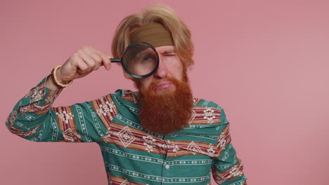 Investigator-researcher-man-with-magnifying-glass-near-face,-looking-into-camera-with-big-zoom-eye