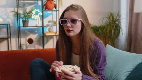 Mujer-Bonita-Sentada-En-Un-Sofá-Comiendo-Palomitas-De-Maíz,-Viendo-Una-Serie-De-Televisión-Interesante,-Un-Juego-Deportivo-En-Línea-En-Casa