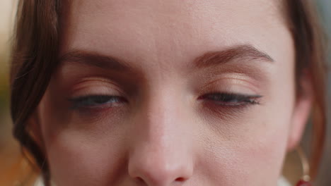 Close-up-macro-portrait-of-young-woman-face-smiling,-brunette-girl-eyes-looking-at-camera-blink-wink