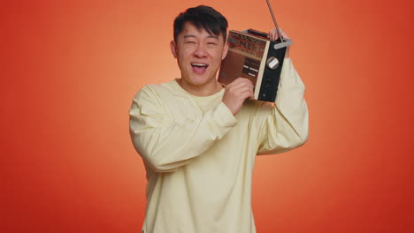 Asian-man-using-retro-tape-record-player-to-listen-music-disco-dancing-of-favorite-track,-having-fun