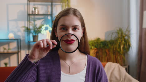 Woman-holding-magnifier-glass-on-teeth,-happy-expression,-showing-funny-smiling-silly-face-mouth