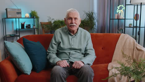 Abuelo-Mayor-Emocionado-En-El-Sofá-Viendo-Una-Interesante-Serie-De-Televisión,-Un-Juego-Deportivo-En-Línea-En-Casa