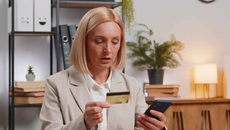 Angry-mad-stressed-businesswoman-trying-to-pay-online-shopping-with-blocked-credit-card-smartphone