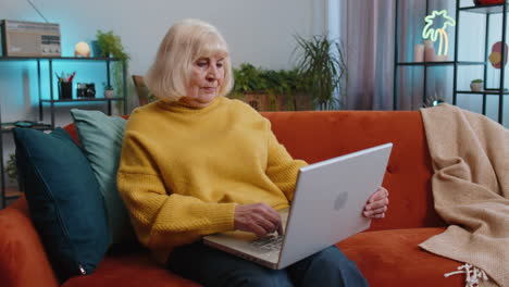 Grandmother-woman-use-laptop-computer,-receive-good-news-message,-shocked-by-victory,-celebrate-win