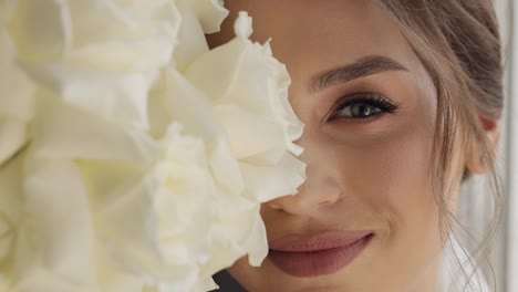 Close-up-of-beautiful-lovely-stylish-bride-girl-looking-at-camera-and-smiling-with-flowers-bouquet