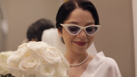 Primer-Plano-De-Una-Hermosa-Novia-Elegante-Con-Gafas-De-Sol-Mirando-A-La-Cámara-Y-Sonriendo,-Mañana-De-Boda