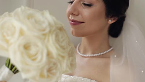 Braut-Im-Weißen-Kleid-Steht-Mit-Blumenstrauß-Am-Fenster,-Hochzeitsvorbereitungen-Am-Morgen-Zu-Hause