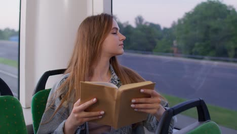 Retrato-De-Una-Atractiva-Joven-Adulta-Sentada-En-Un-Tren-Subterráneo-Vacío-Y-Leyendo-Un-Libro-Interesante