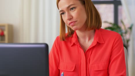 Young-woman-having-talk-video-call-on-laptop-computer-at-home..Handheld-low-angle-view-shot,-Female-freelancer-explaining-project-in-online-meeting-with-team-members-via-laptop-in-home-office.-Working-from-home,-Remote-working.