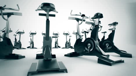 Animation-of-modern-gym-equipment-stationary-bikes-standing-in-a-circle.-Indoor-cycling-activity-machines-helping-to-stay-fitness-even-if-the-weather-outside-is-not-good-for-a-ride.-Loopable.-HD