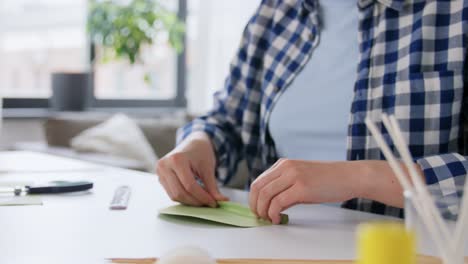 Frau-In-Einer-Handwerkswerkstatt-Macht-Skizzen-Auf-Rosa-Papier.-Frau-In-Einer-Handwerkswerkstatt-Macht-Skizzen-Auf-Rosa-Papier